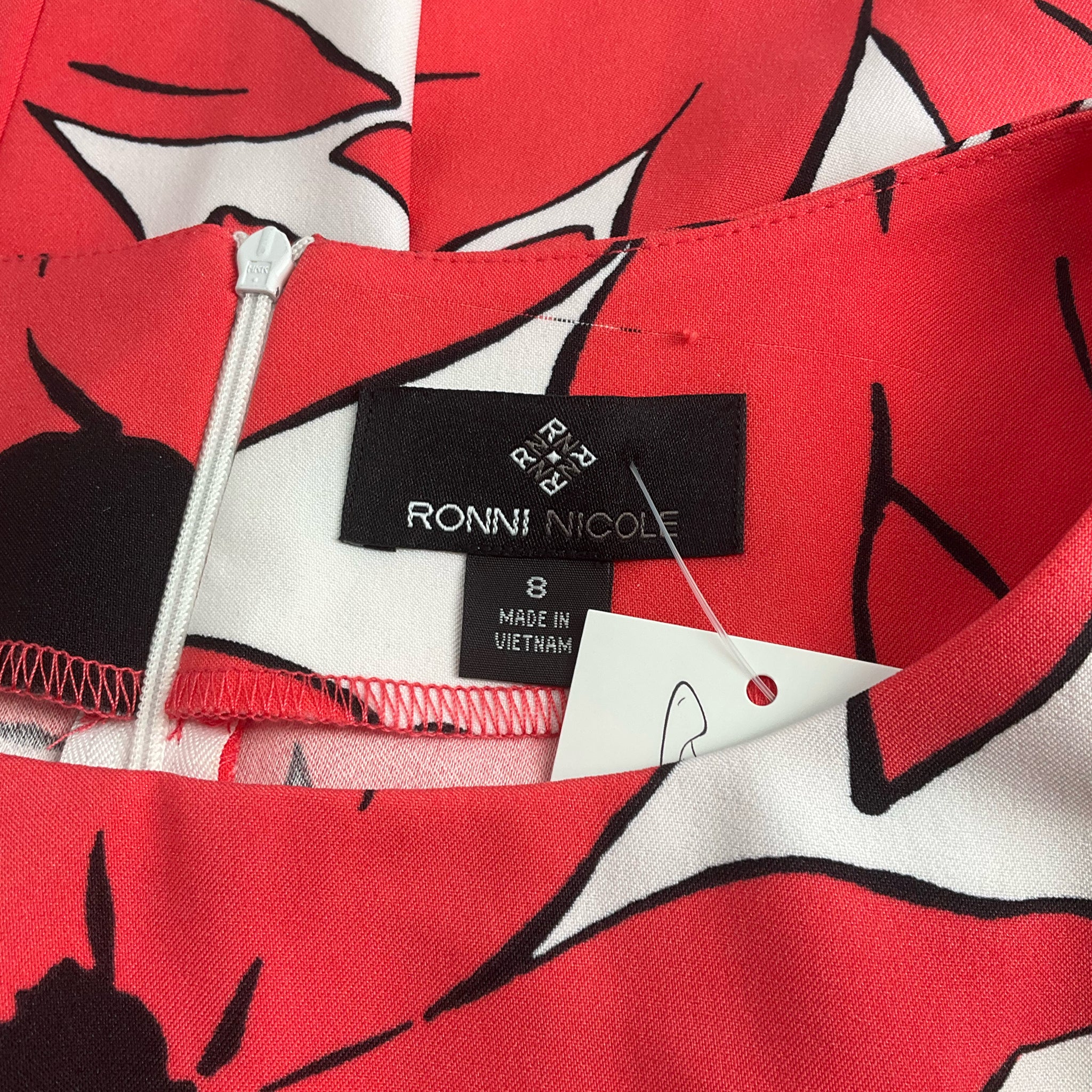 Close-up of Ronni Nicole brand label and size tag on the White/Coral Floral Dress - Size 8, confirming authenticity and fit.