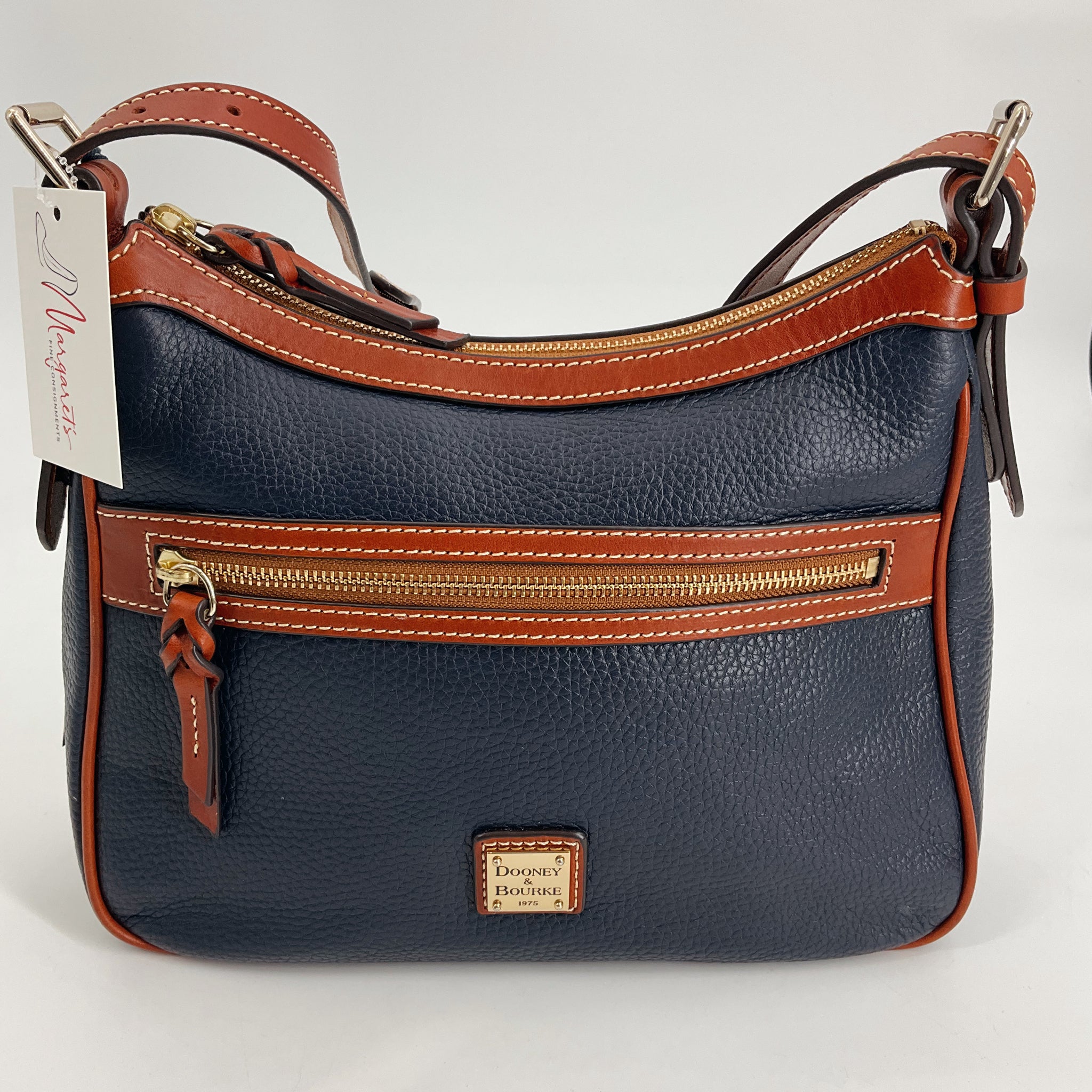Dooney & Bourke Navy/Brown Pebble Purse with gold-tone zipper and tag, new with tags, available at Margaret’s Fine Consignments.
