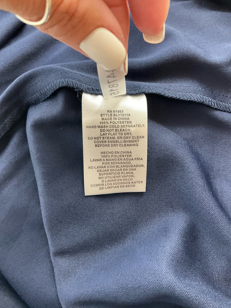 Care label of SLNY navy dress, size 10, showing fabric content and washing instructions for this formal chiffon garment.