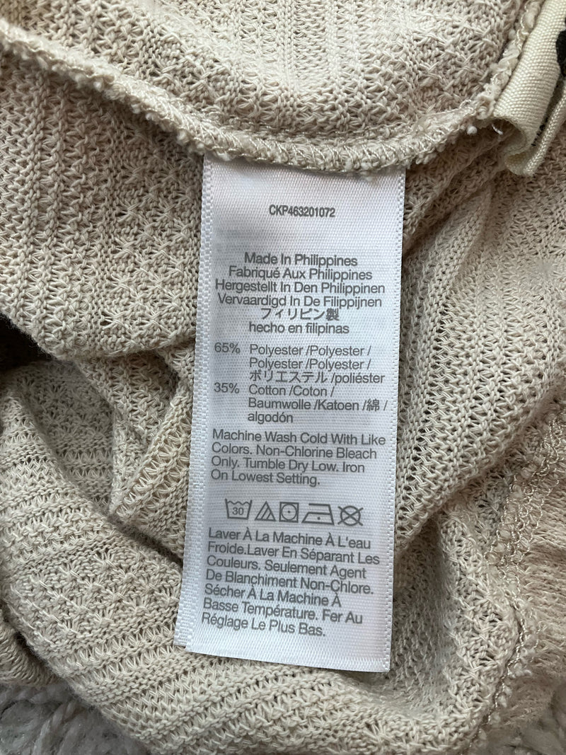 Fabric care label of Madewell tan cardigan sweater showing 65% polyester and 35% cotton blend. Machine washable, made in the Philippines.