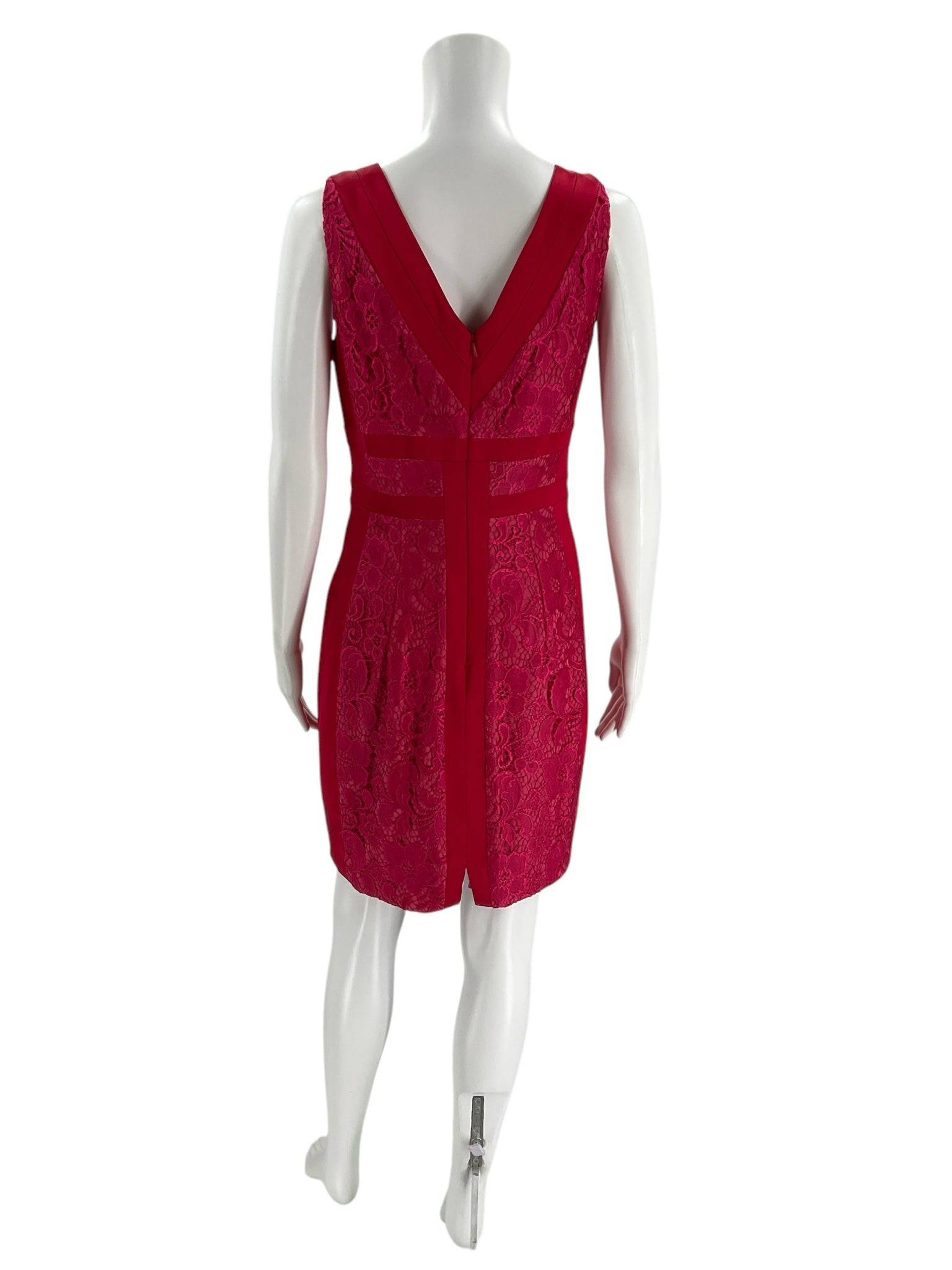 Back view of Jax V Neck Mini Dress Size 8 in pink lace on mannequin, showcased at Margaret’s Fine Consignments. Elegant mini dress with deep V back.