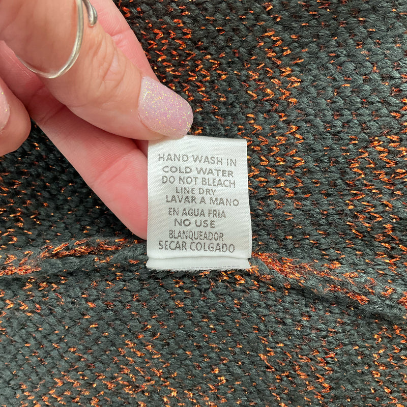Care label for Entro Gray/Copper Print Top advising hand wash in cold water and line dry, ensuring garment longevity and quality.