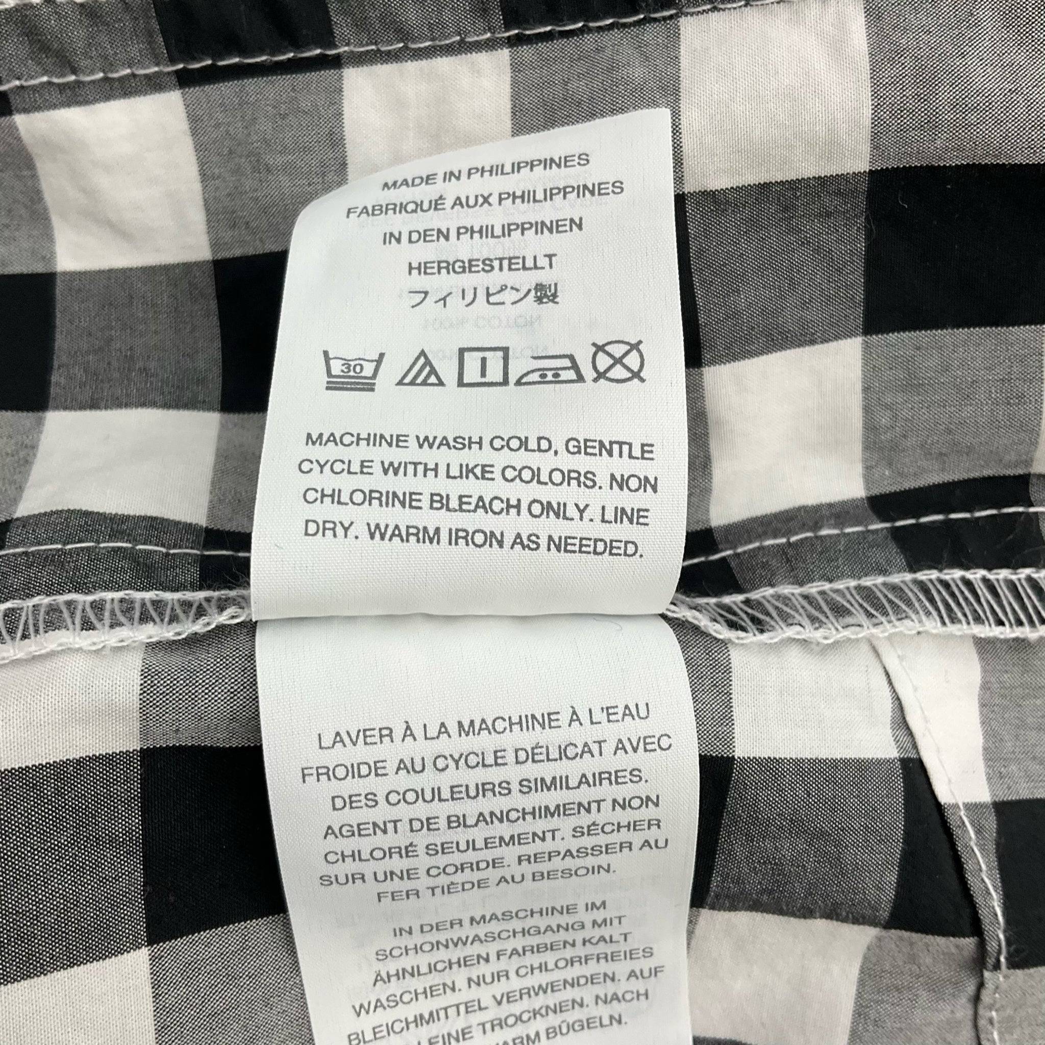 Care instruction label for J Crew Print Mini Dress Size Medium, detailing machine wash cold and gentle cycle, sold by Margaret’s Fine Consignments.