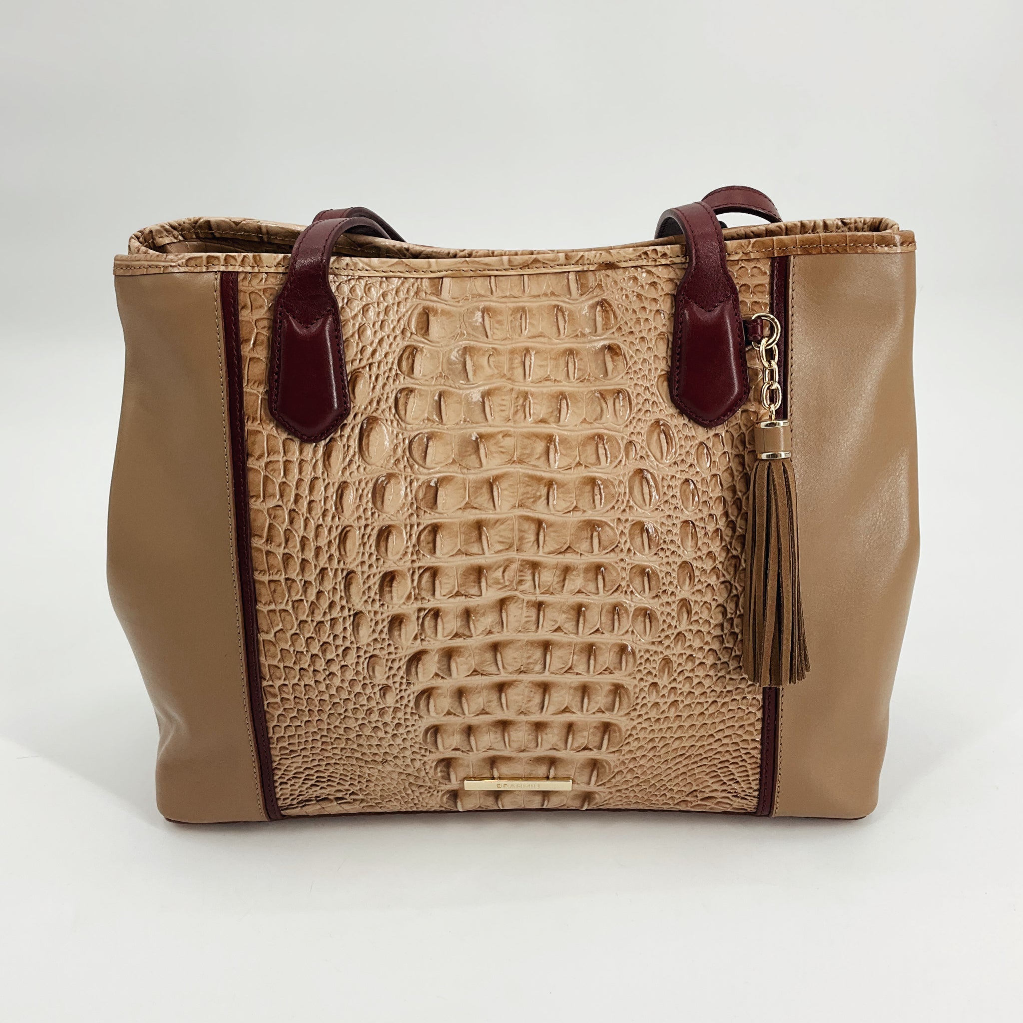 Brahmin Tan Crocodile Handbag with textured leather center panel, burgundy handles, and tassel charm. New with tags, pre-owned luxury purse.