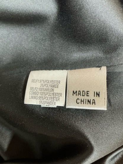 Close-up of fabric content label showing polyester, nylon, and spandex blend for Kay Unger black floral brocade dress, made in China.