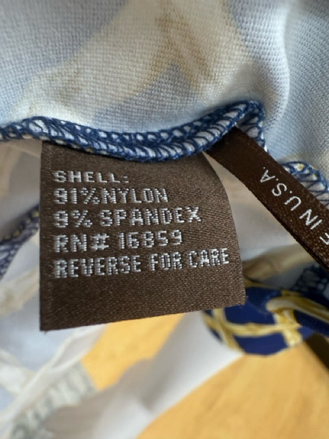 Close-up of fabric tag on Jj Mclaughlin Blue/Gold Print Dress showing 91% nylon and 9% spandex blend, made in the USA.