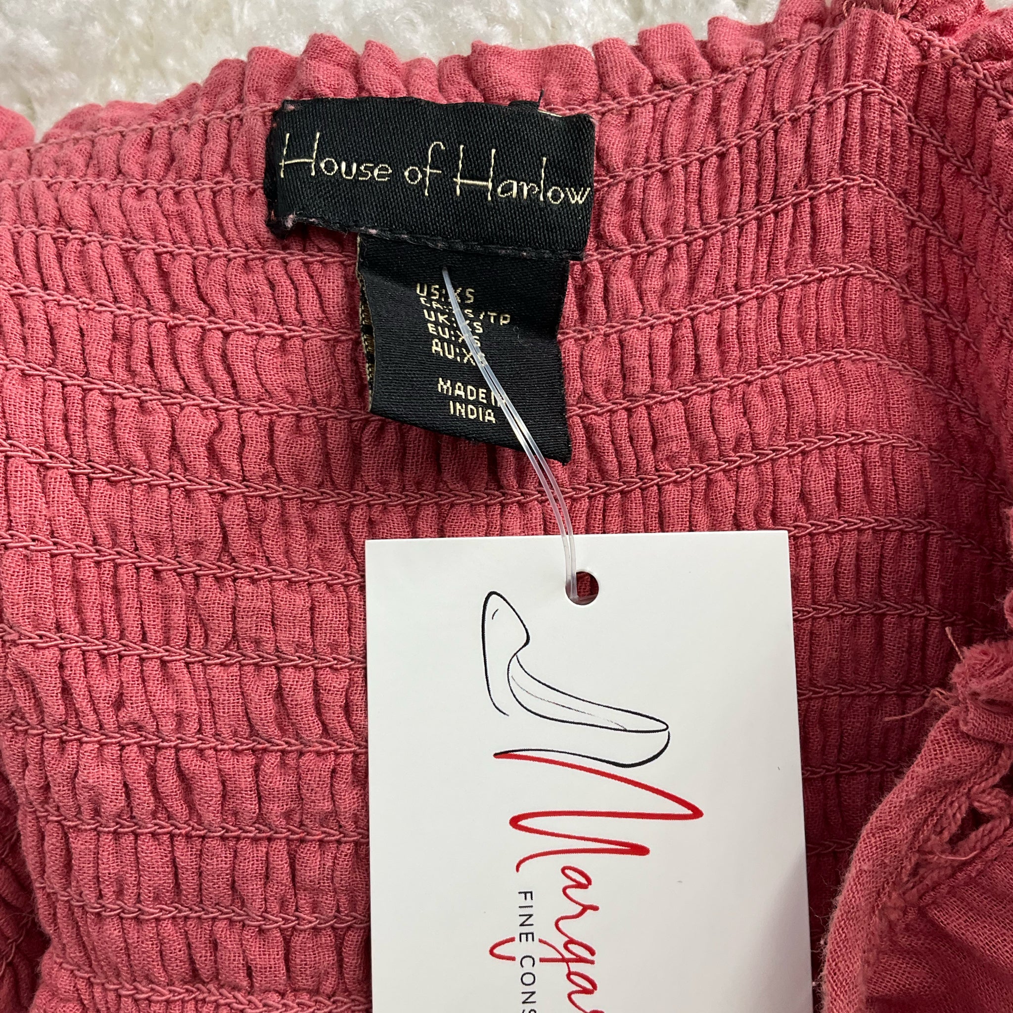 Close-up of House of Harlow brand label on Salmon Eyelet Dress - Size XS, confirming authenticity and pre-owned status from Margaret's Fine Consignments