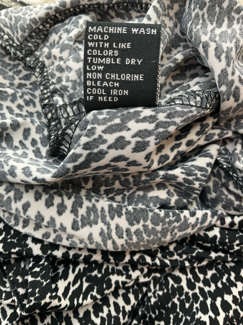 Care label for Peck & Peck animal print dress, medium size, indicating machine wash cold, tumble dry low, and cool iron if needed.