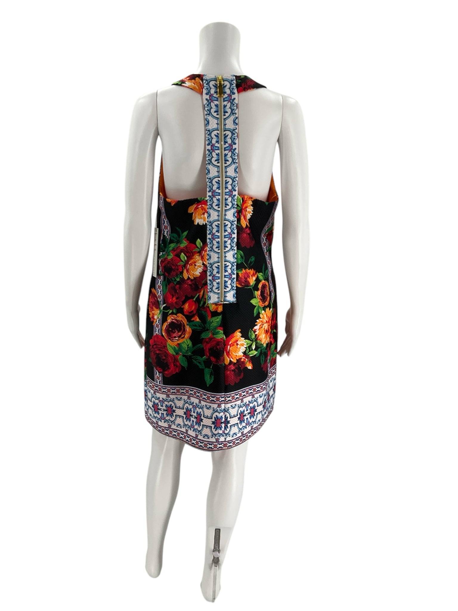 Back view of Nicole Miller Black & Multi Floral Dress – Size 6 showing open back with central printed strap and floral border hem, new with tags.