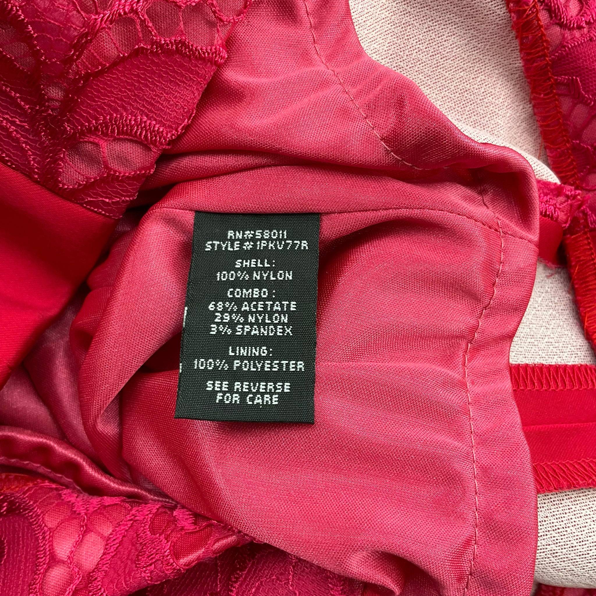 Fabric content label of Jax V Neck Mini Dress Size 8 in pink lace, highlighting material details at Margaret’s Fine Consignments. Sustainable fashion choice.