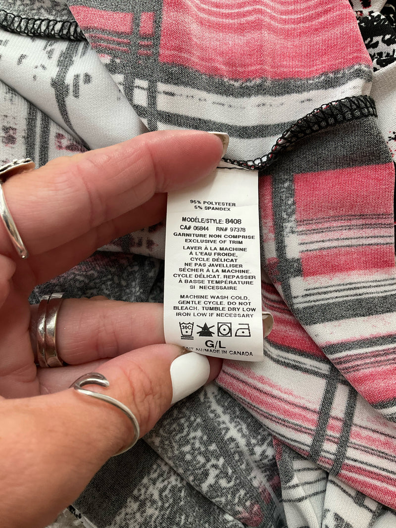 Fabric care label of Dusak Designs dress, style 8408, made in Canada, 95% polyester, 5% spandex, machine washable, size large.