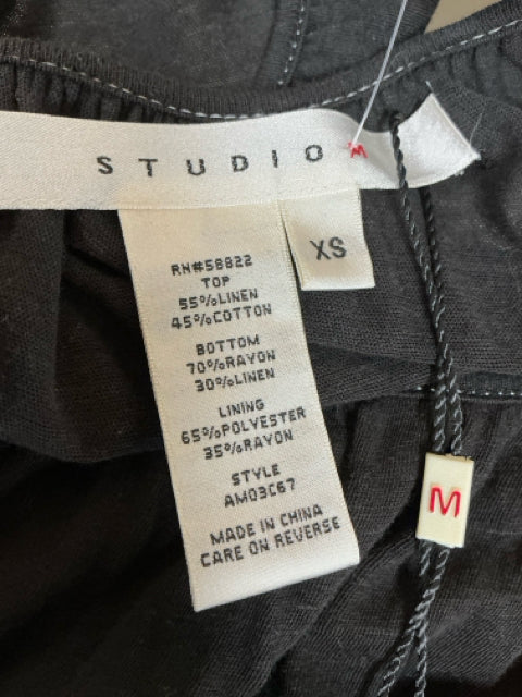 Studio M dress label showing size XS and fabric composition. Top: 55% linen, 45% cotton; Bottom: 70% rayon, 30% linen; Lining: 65% polyester, 35% rayon.