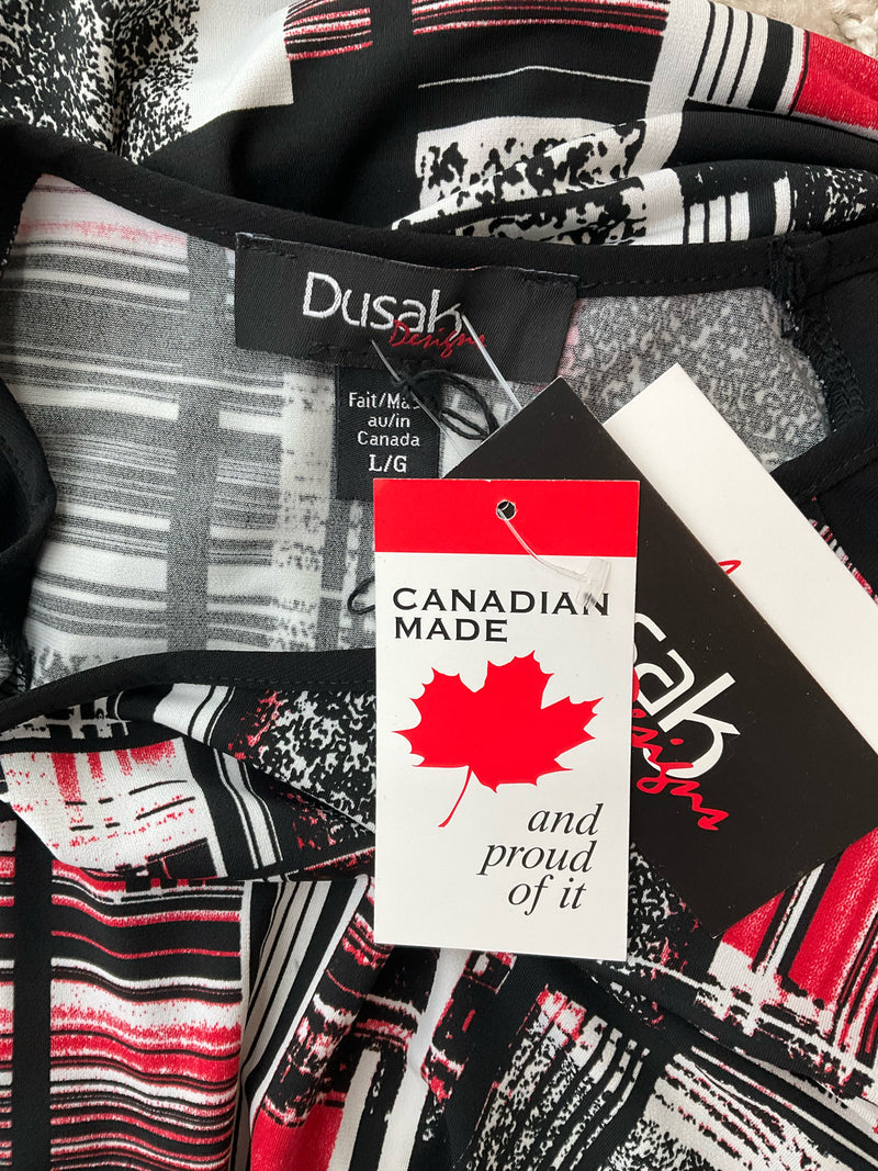 Close-up of Dusak Designs dress tags showing 'Canadian Made' label and brand tag, confirming new with tags status and origin.