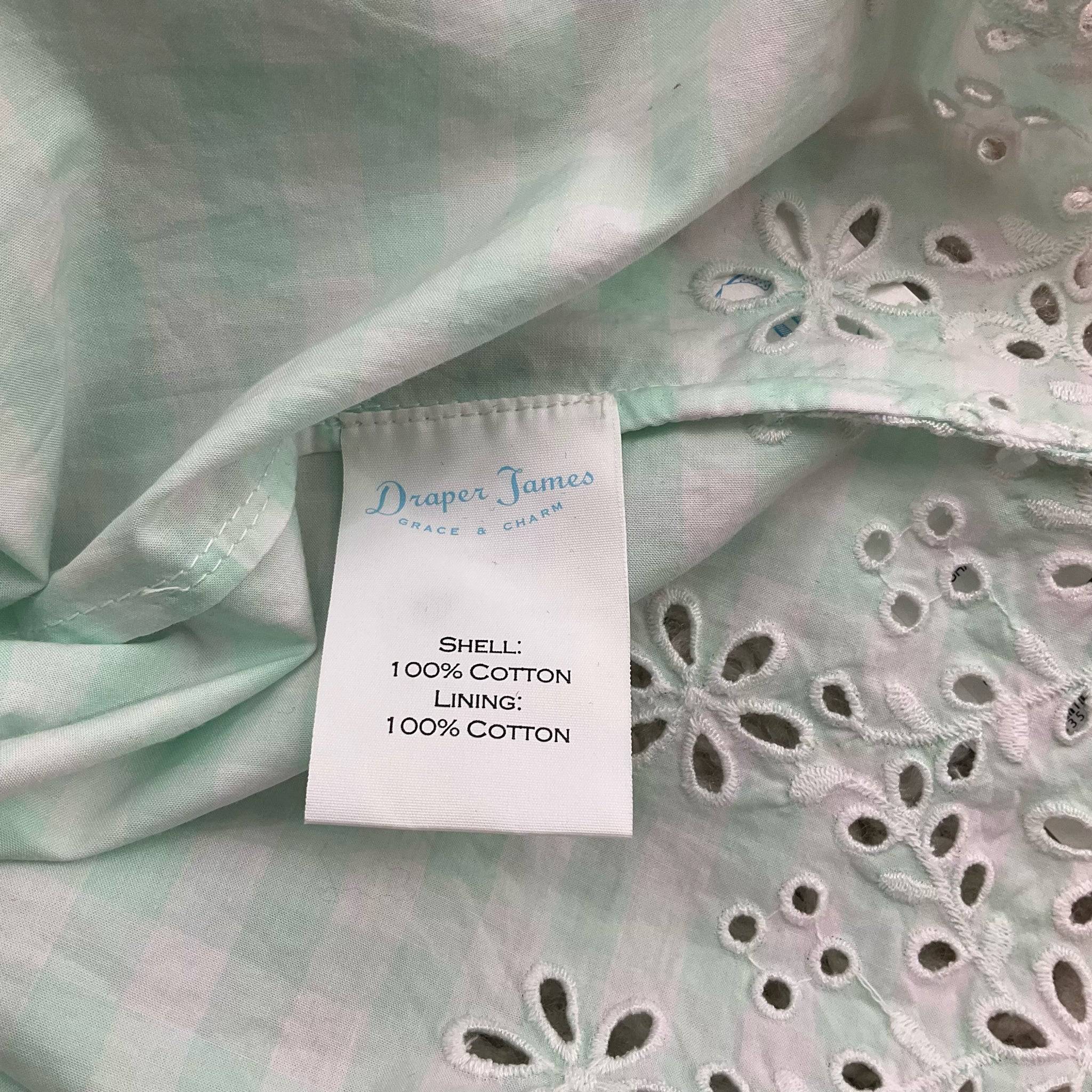 Fabric tag showing Draper James Dress made of 100% cotton shell and lining, emphasizing breathable comfort for spring and summer.