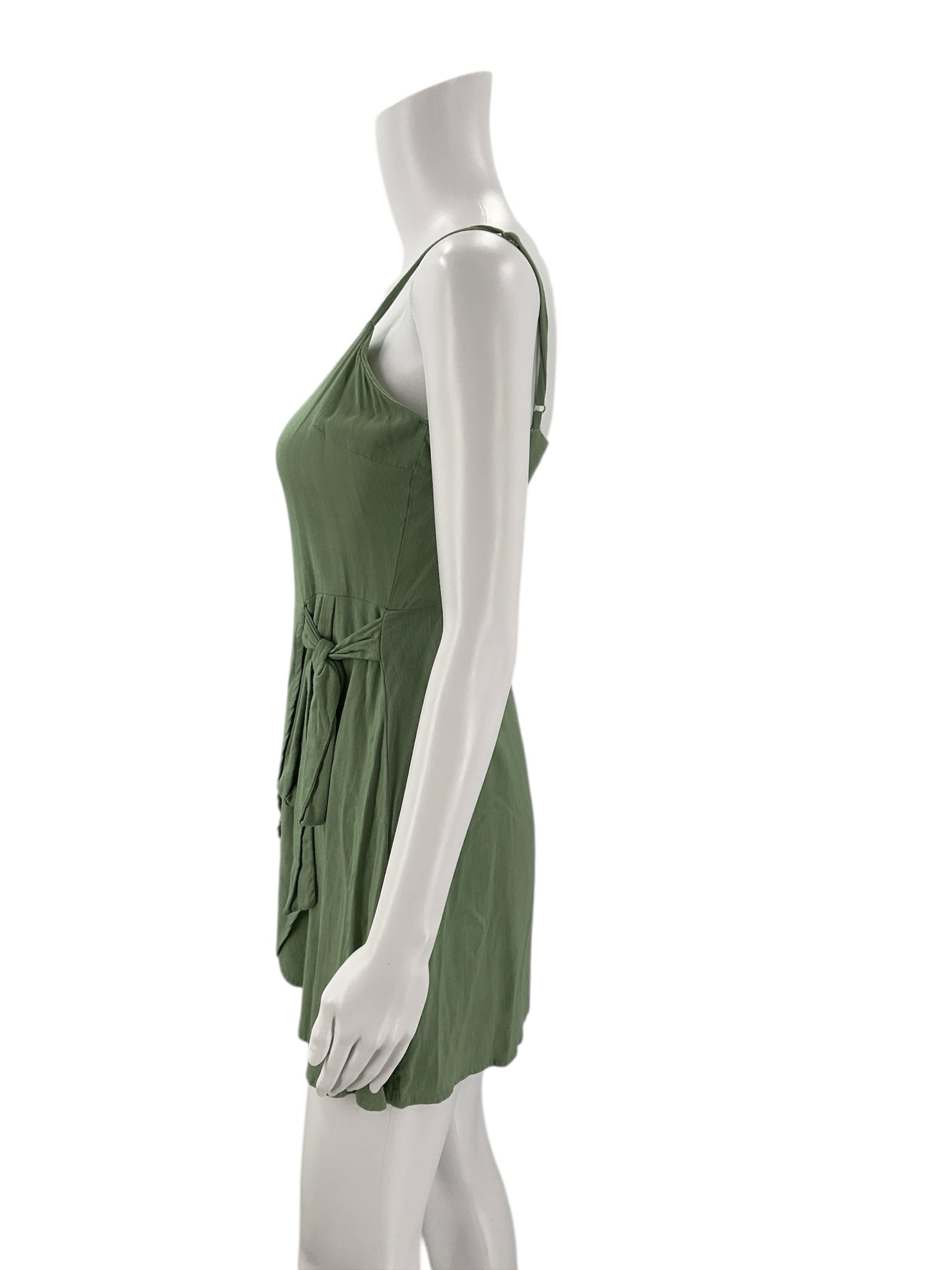 Side profile of Altar'd State Green Solid Dress - Size XS featuring a flattering tie waist and mini length, perfect for summer outings.
