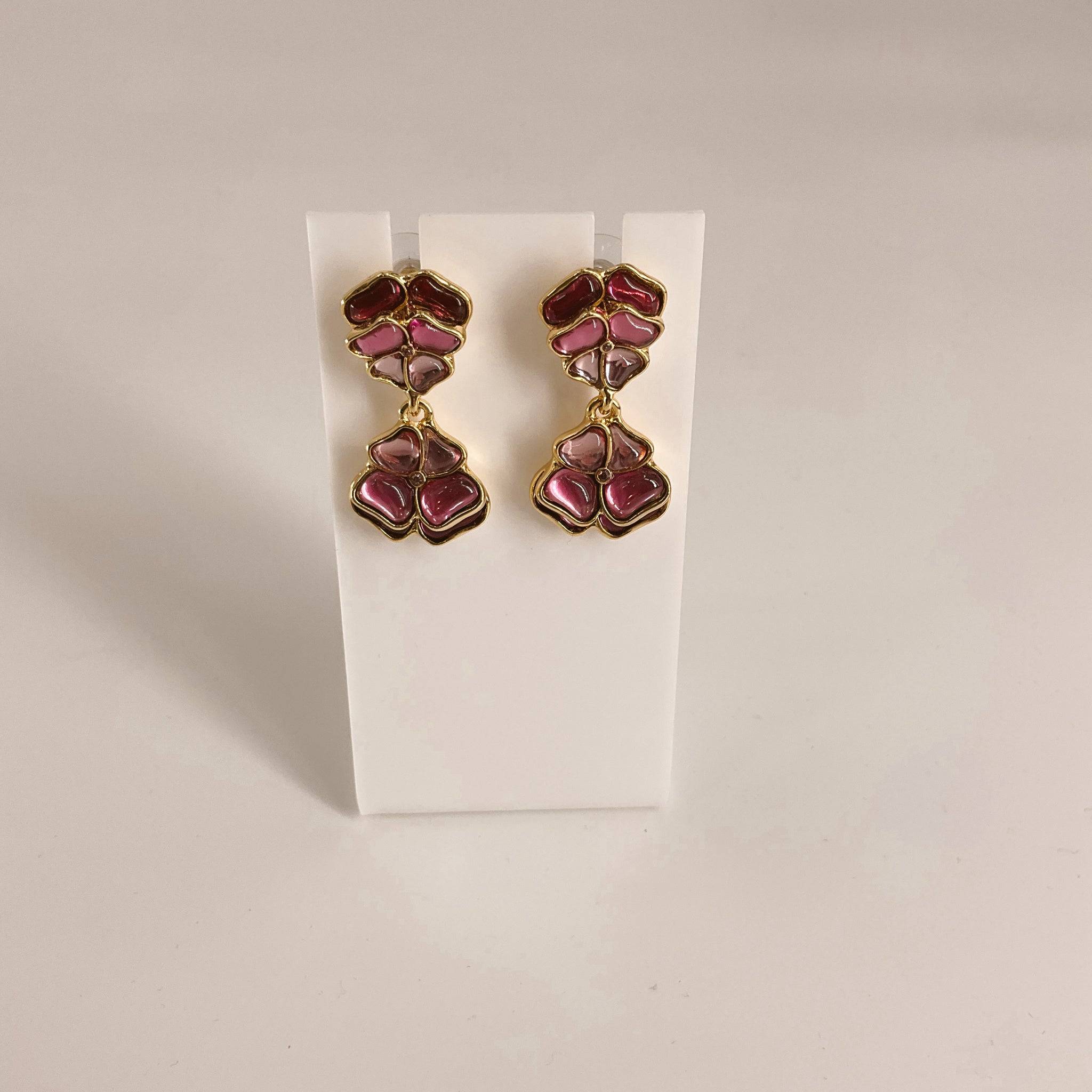 Gold/Purple Earrings featuring a dual floral drop design with glossy enamel finish. Elegant accessory ideal for fashion jewelry collections.