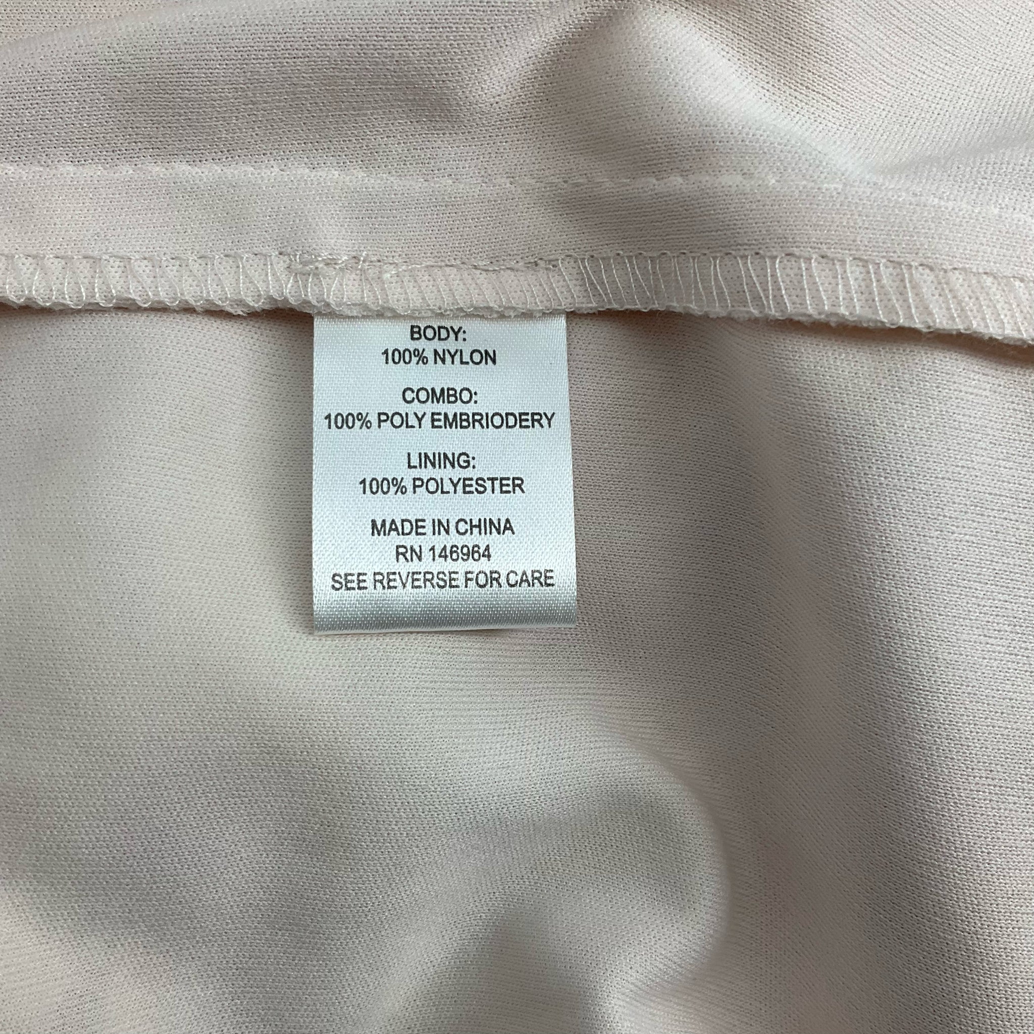 Fabric content label of Donna Ricco Peach/Cream Floral Dress - Size 10, listing nylon body, polyester embroidery, and polyester lining.