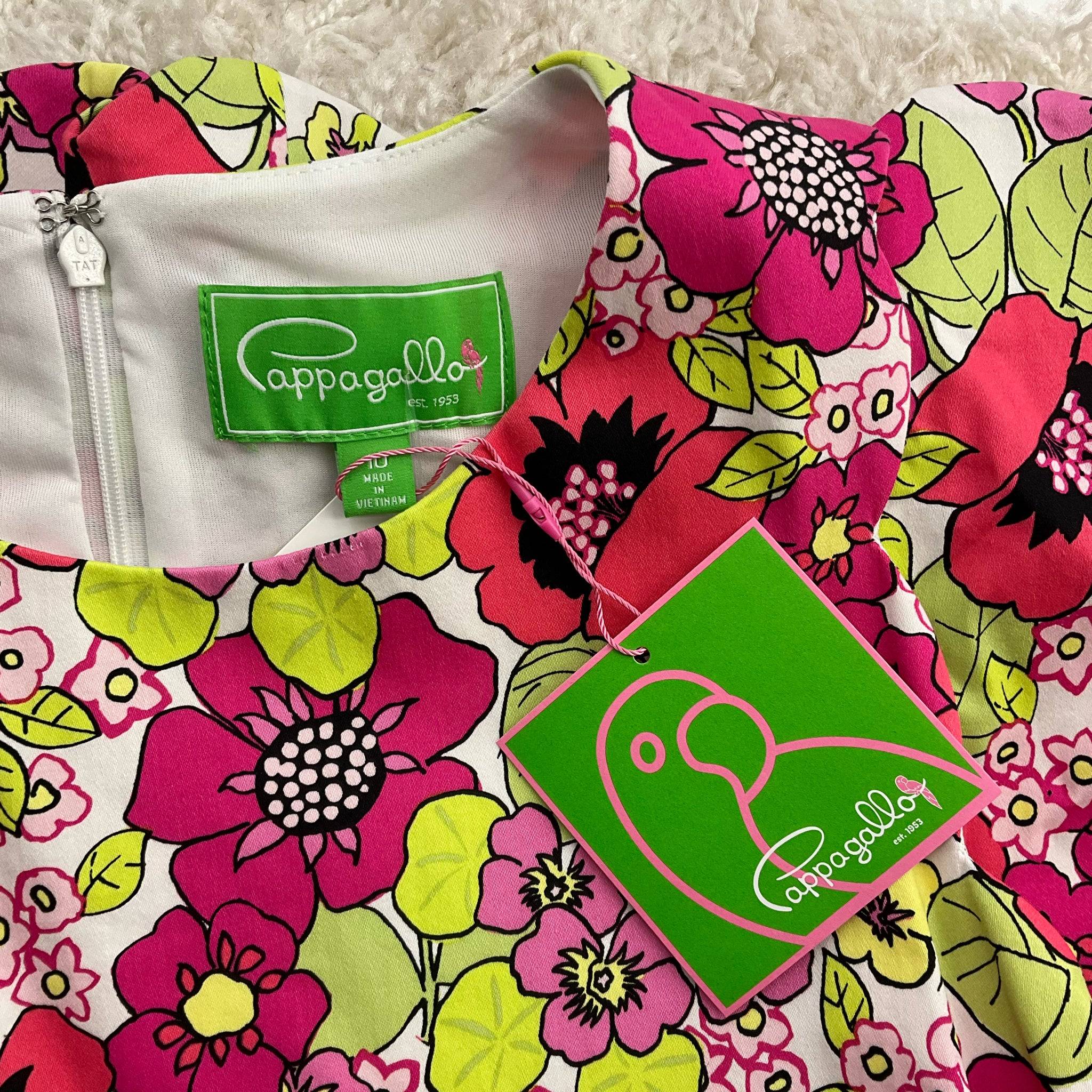 Close-up of Cappagallo dress neckline showing green brand tag and attached new tag, floral coral, pink, and green design, size 10.