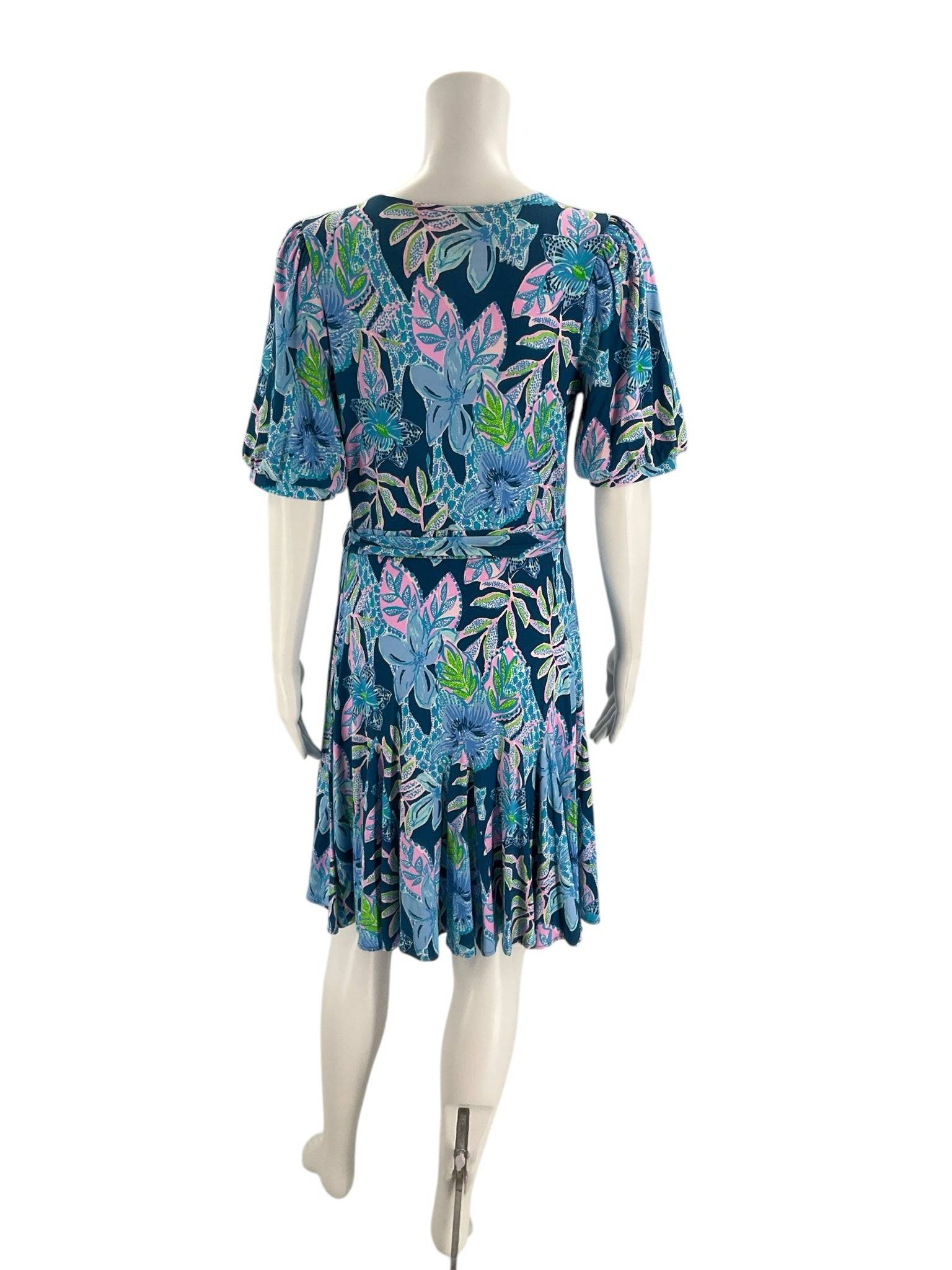 Back view of Lilly Pulitzer Blue & Multi-Color Floral Dress – Size S on mannequin, highlighting pleated hem and colorful floral design. Pre-owned mini dress.