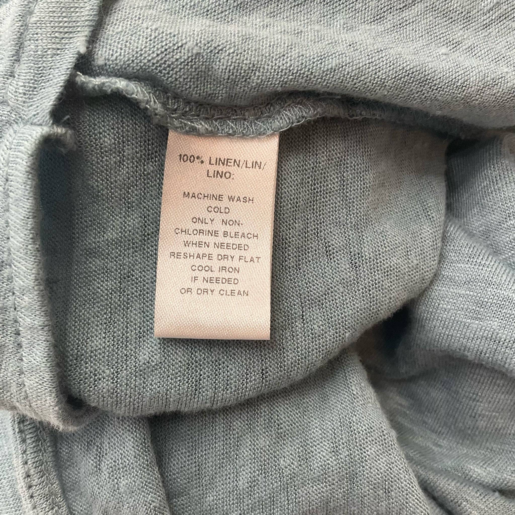 Fabric tag of Loft Blue Heathered Top - Size Small showing 100% linen material and care instructions for long-lasting wear.