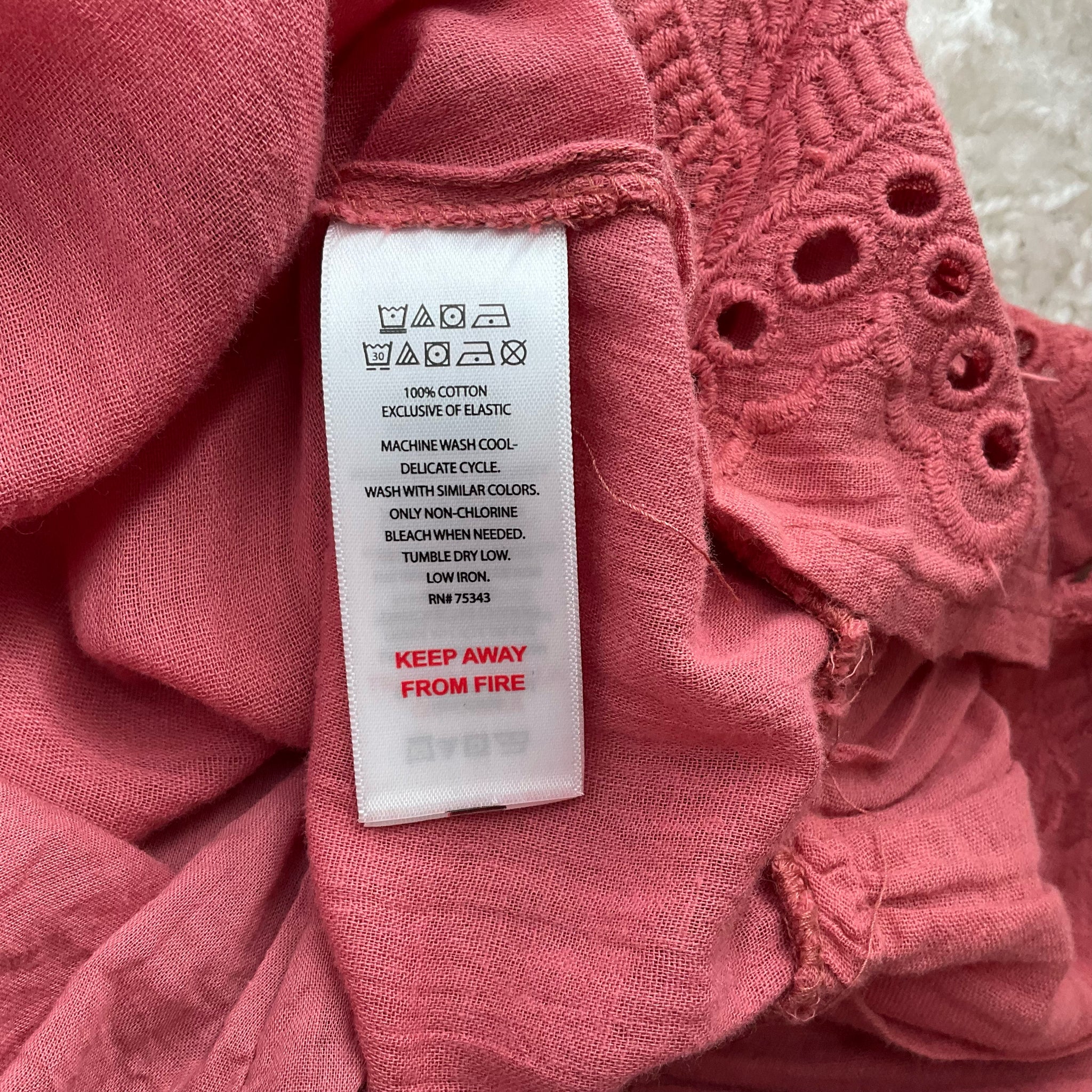 Fabric care label of House of Harlow Salmon Eyelet Dress - Size XS showing 100% cotton material and washing instructions, gently used condition