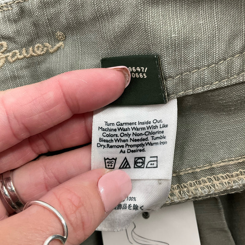 Care label on Eddie Bauer Olive Shorts - Size 8 with washing instructions, ensuring long-lasting wear and easy maintenance.