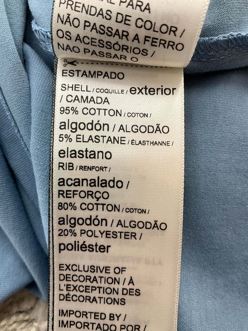 Fabric content label of Puma Essentials Tank Dress, made of 95% cotton and 5% elastane for comfort and stretch in athletic wear.