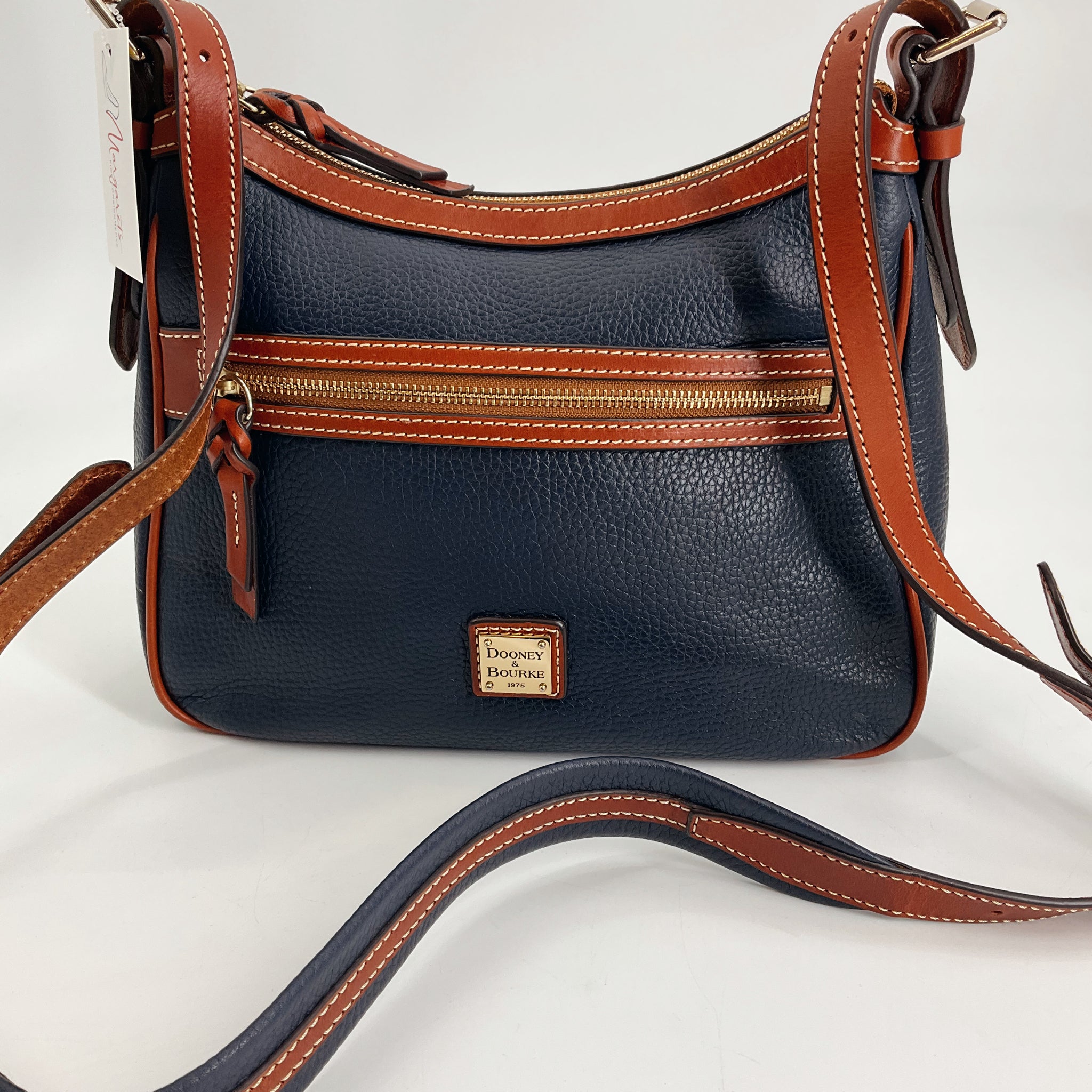 Back view of Dooney & Bourke Navy/Brown Pebble Purse featuring adjustable strap and exterior zip pocket, pre-owned and new with tags.