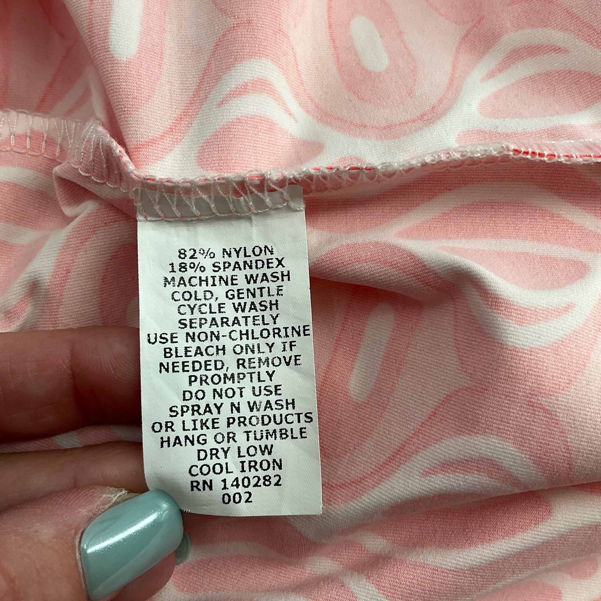 Fabric care label of Katherine Way Coral/White Print Dress - Size Small showing nylon/spandex blend and washing instructions.