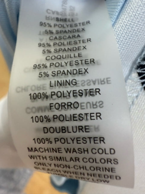 Close-up of fabric care label on Vince Camuto dress showing polyester-spandex blend shell and 100% polyester lining, machine washable.