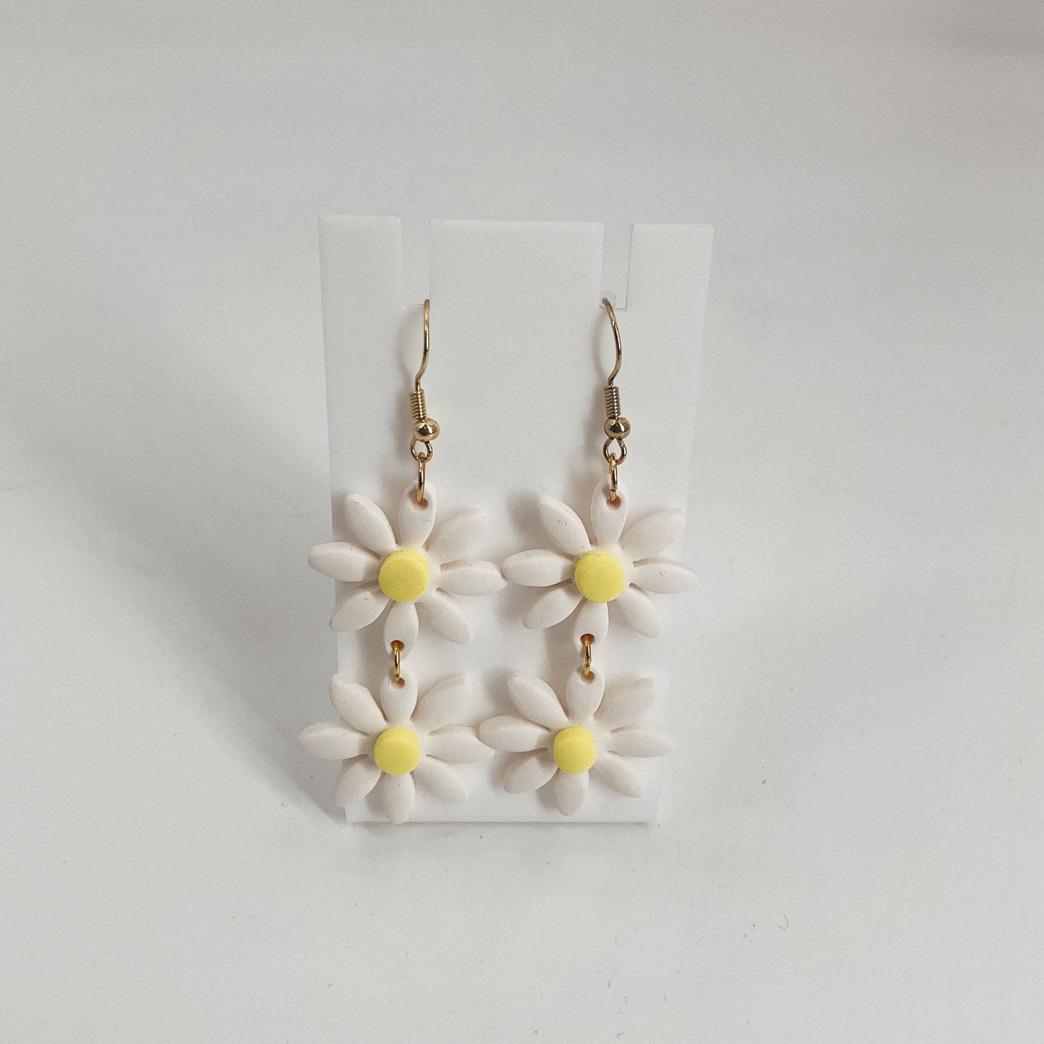 Handmade daisies earrings featuring double white daisy flowers with yellow centers and gold hooks, perfect for spring fashion accessories.