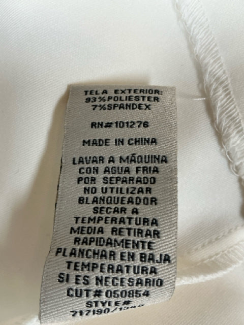 Spanish fabric care label of Eci White Solid Sleeveless Pre-Owned Ladies Dress - Size 10 with material composition and care directions.