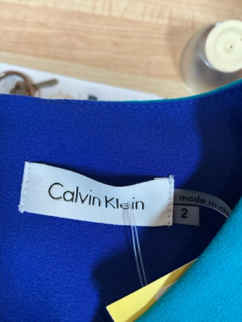 Interior label of Calvin Klein teal dress, size 2, confirming brand authenticity and sizing for pre-owned apparel shoppers.