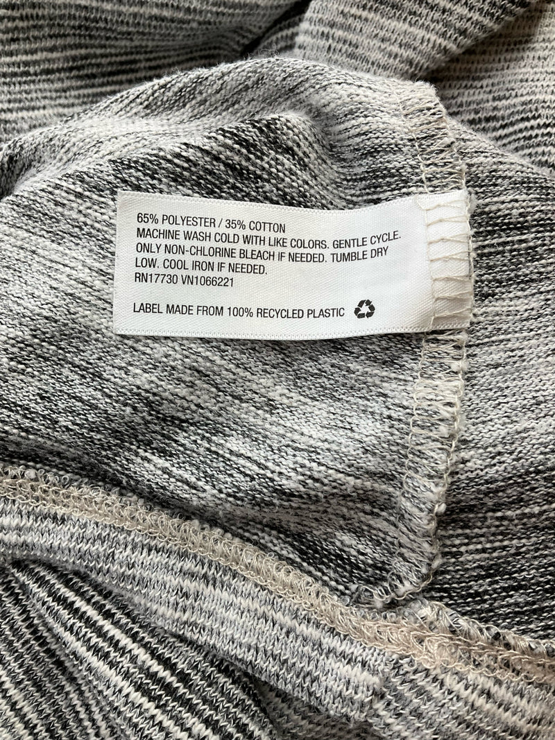 Fabric care label of Mossimo gray swing dress, indicating 65% polyester and 35% cotton blend with eco-friendly recycled plastic label.