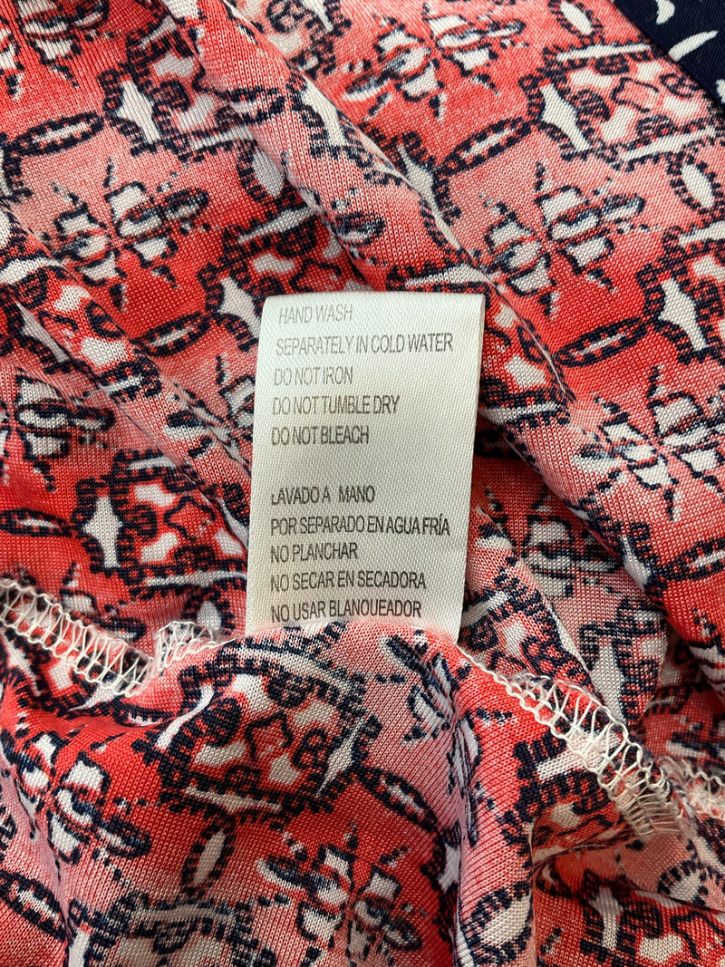 Care label of Western Connection orange navy midi dress with hand wash instructions, emphasizing gentle care for long-lasting resort wear appeal.