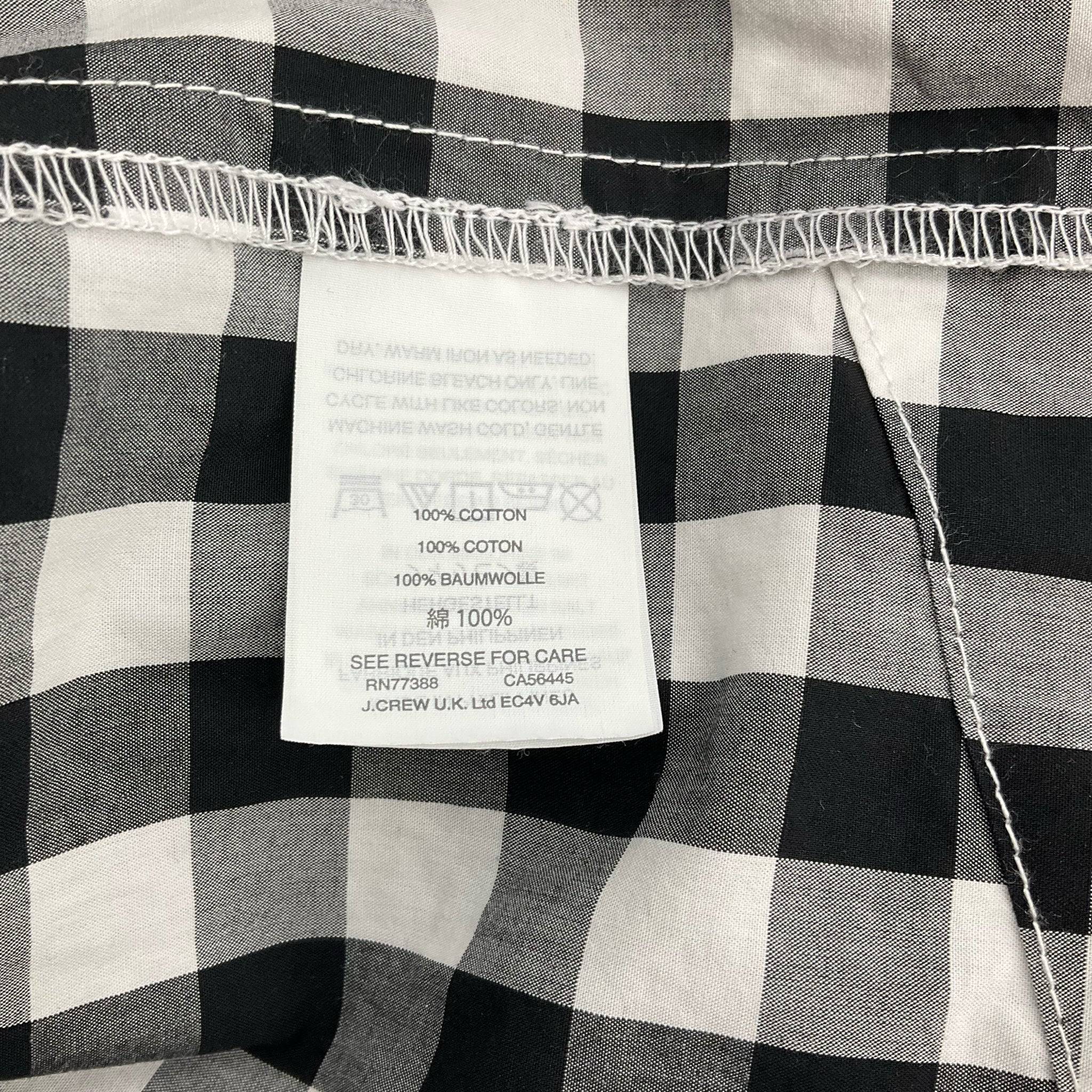 Fabric content tag showing 100% cotton material on J Crew Print Mini Dress Size Medium, black and white checkered, at Margaret’s Fine Consignments.