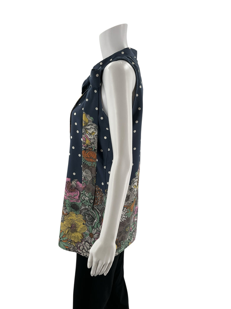 Side profile of Les Amis sleeveless navy blouse featuring polka dots and floral border, tie-neck detail, size small, pre-owned boho top.