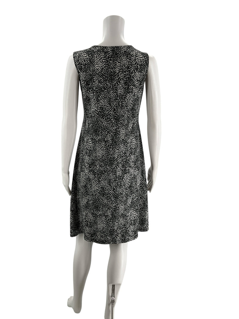 Back view of Peck & Peck white/black print empire waist dress, size medium, showcasing knee-length hem and sleeveless cut.