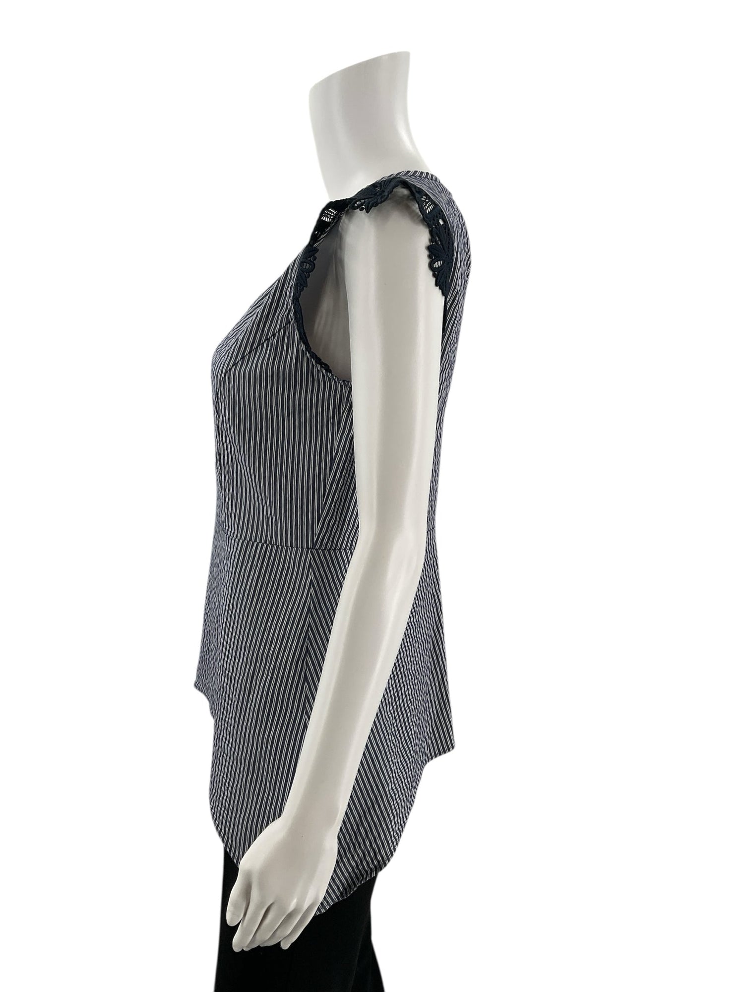 Side profile of Cabi Tapestry Top XS on mannequin, showing the curved hem and fitted silhouette with black lace detailing on the sleeves.