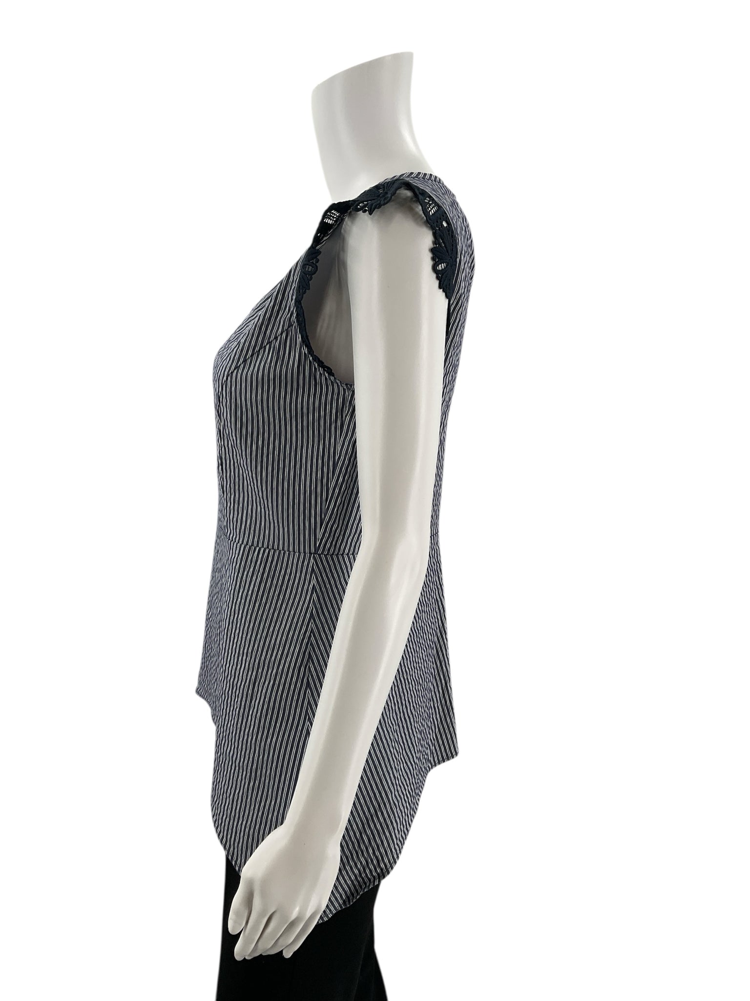 Side profile of Cabi Tapestry Top XS on mannequin, showing the curved hem and fitted silhouette with black lace detailing on the sleeves.