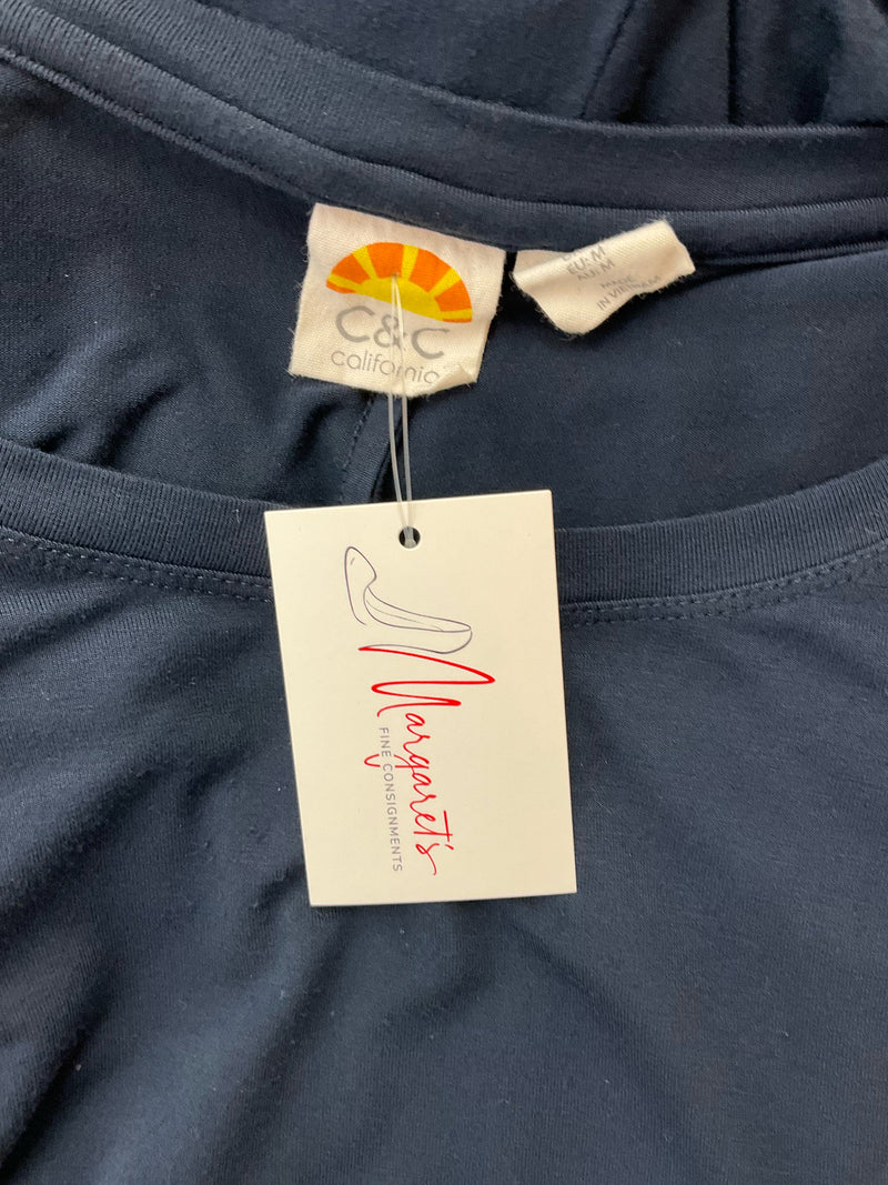 Close-up of C&C California brand label and attached resale tag on navy pre-owned ladies dress, size medium.