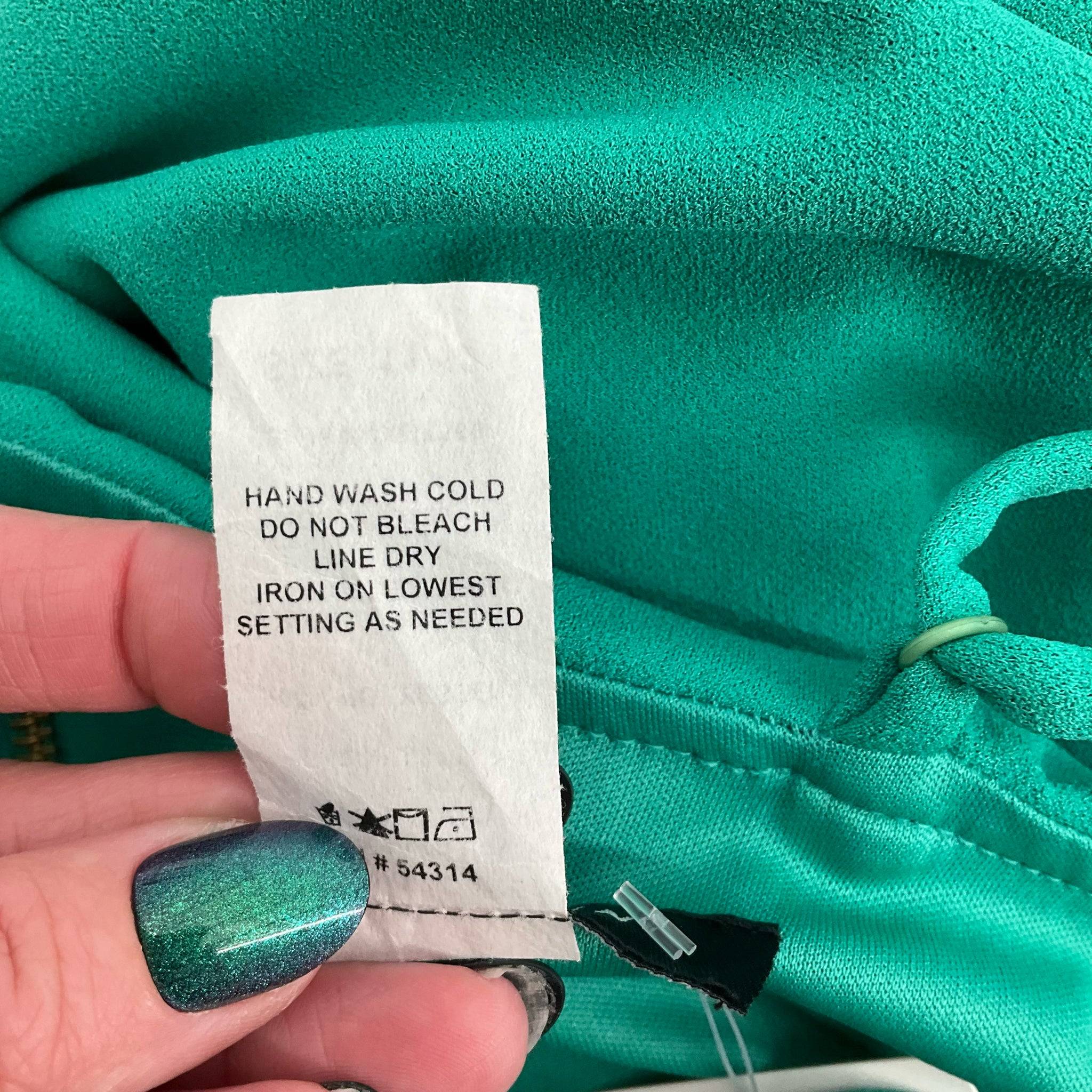 Care instruction tag for B Darlin green mini dress size 11/12, highlighting hand wash and line dry, sold at Margaret’s Fine Consignments.
