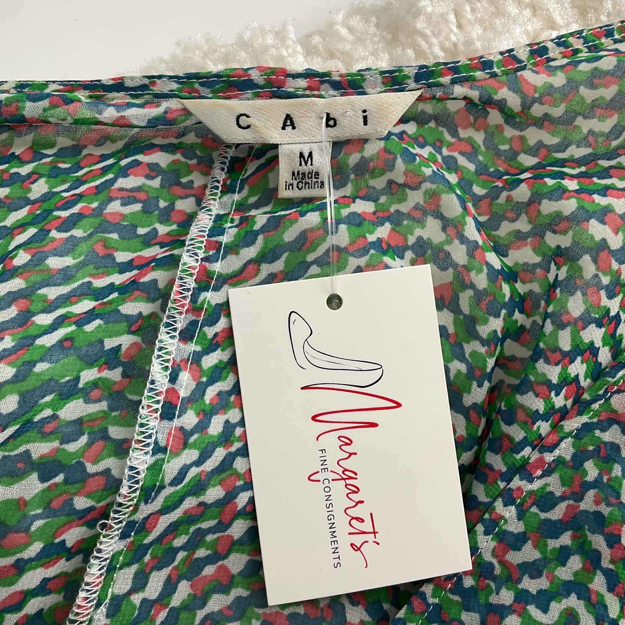 Cabi brand tag on Blue/Green/Pink Print Top - Size Medium with Margaret’s Fine Consignments label. Pre-owned casual top made in China.