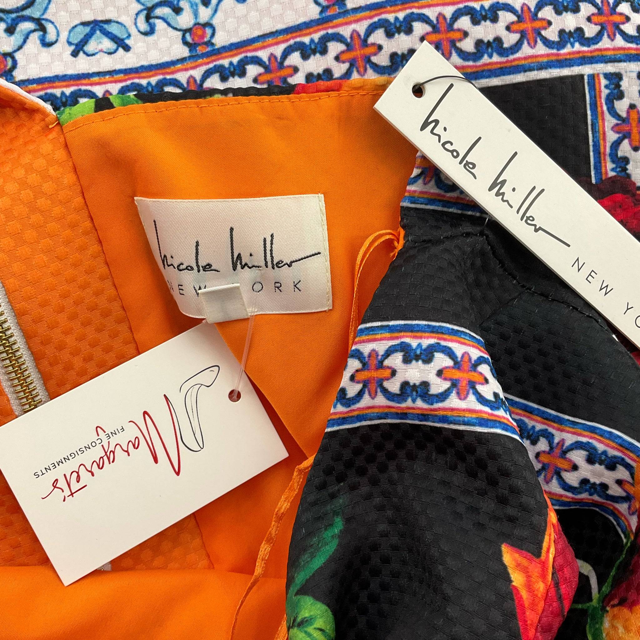 Close-up of Nicole Miller dress tags showing brand label and attached retail tag, confirming authenticity and new condition of the floral dress.