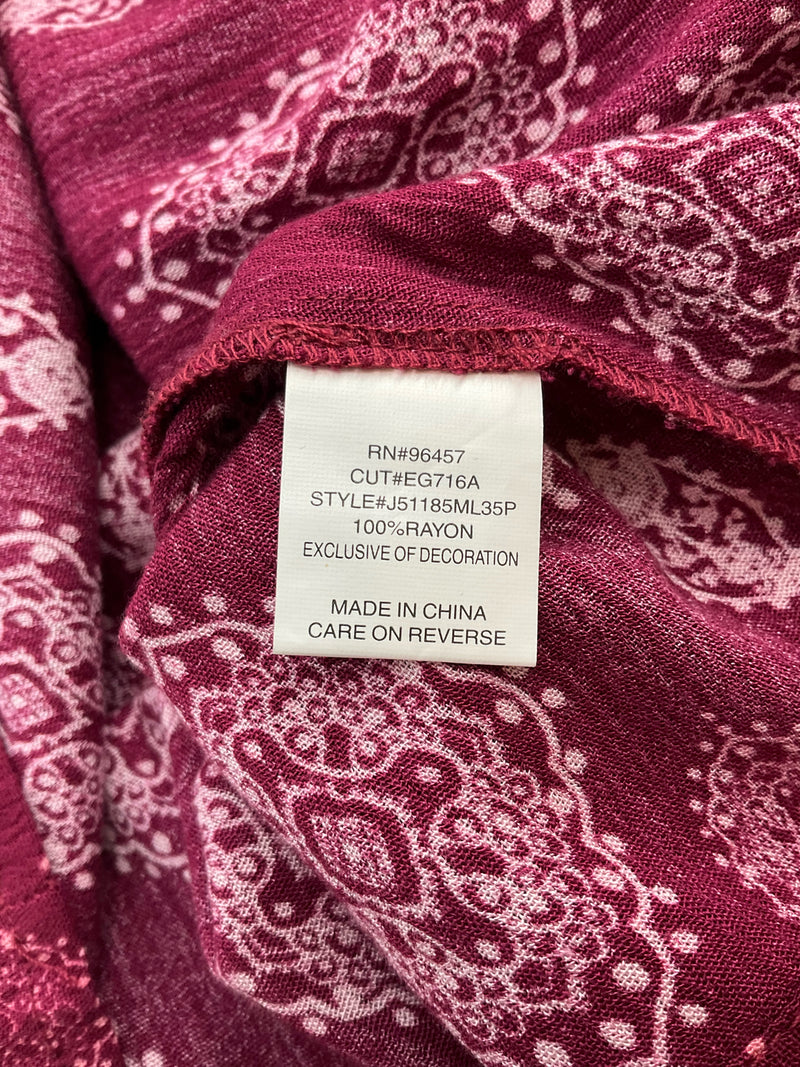 Fabric content label on Luq maroon/pink cami top, indicating 100% rayon material and style number J51185ML35P for sustainable fashion shoppers.