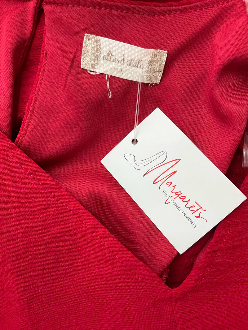 Close-up of Altar'd State brand label and Margaret's Fine Consignments tag on red pre-owned dress, confirming authenticity and resale origin.