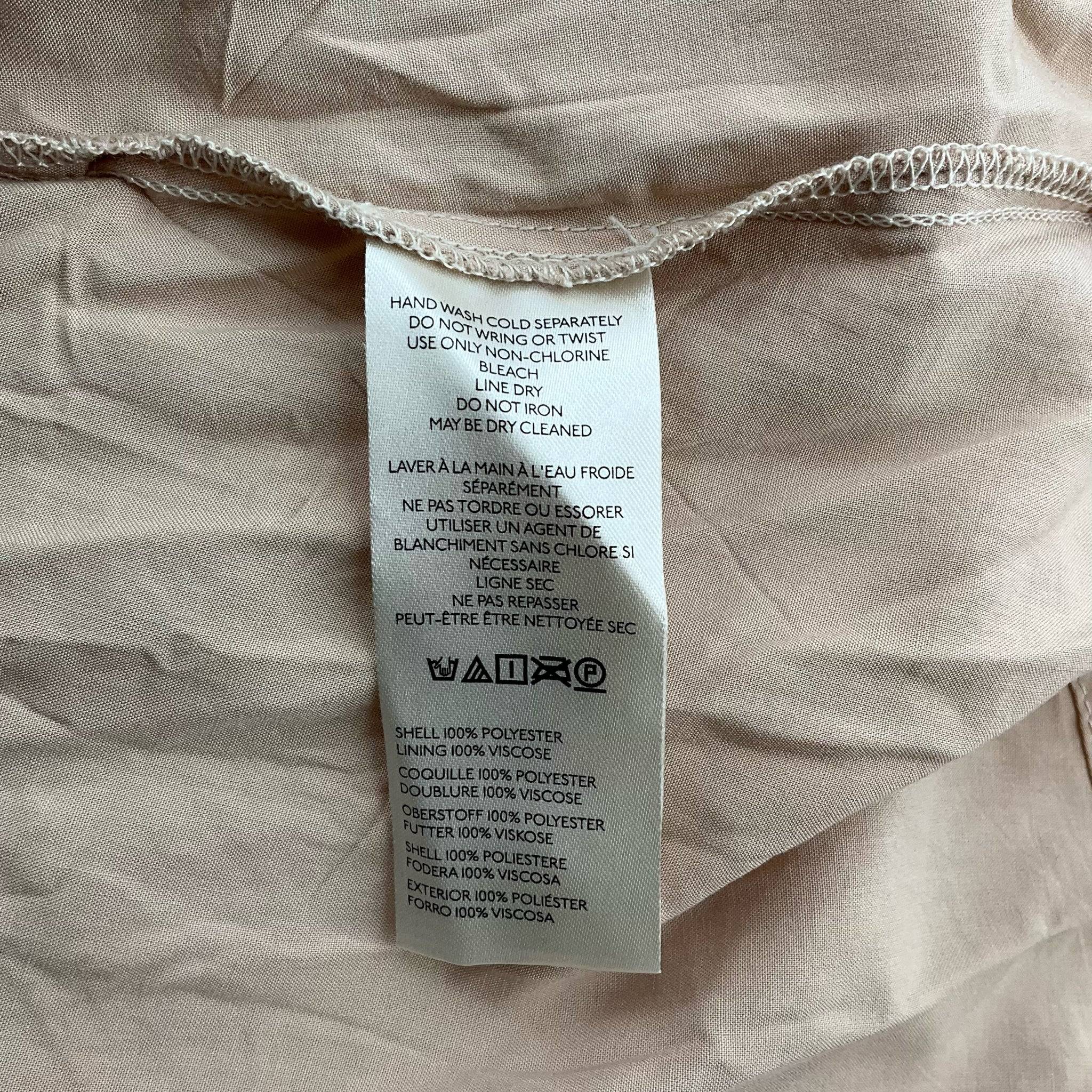 Maeve Dress Size Medium from Margaret’s Fine Consignments, close-up of care label detailing fabric composition and washing instructions.